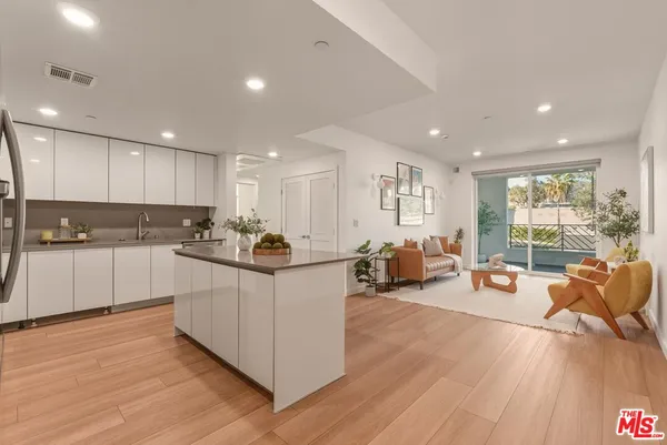 a kitchen with counter top space a sink cabinets and wooden floor
