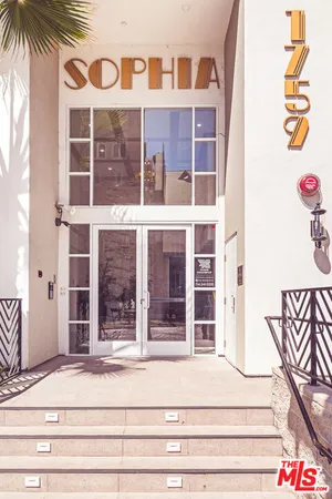 a view of a tall building with palm tree in the background