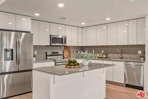 a kitchen with stainless steel appliances granite countertop a refrigerator sink and microwave