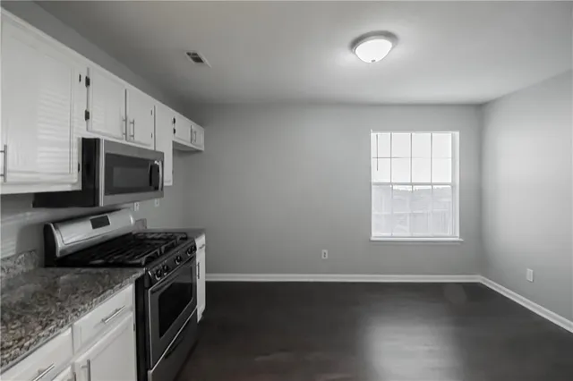 a kitchen with stainless steel appliances stove microwave and cabinets
