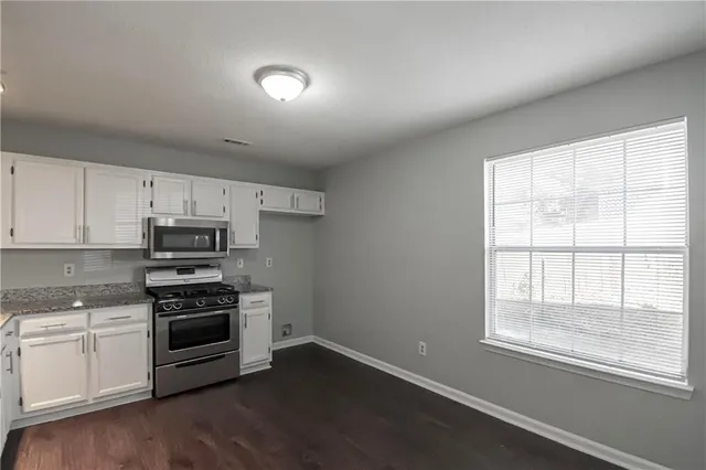 a kitchen with wooden floors and appliances
