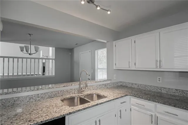 a kitchen with granite countertop a sink and cabinets