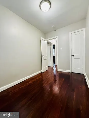 a view of empty room with wooden floor and window