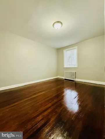 a view of room with window and wooden floor
