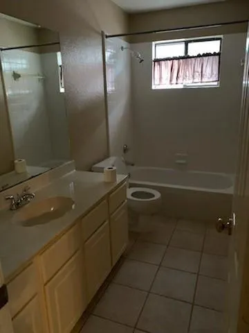 a bathroom with a granite countertop sink a toilet and a mirror