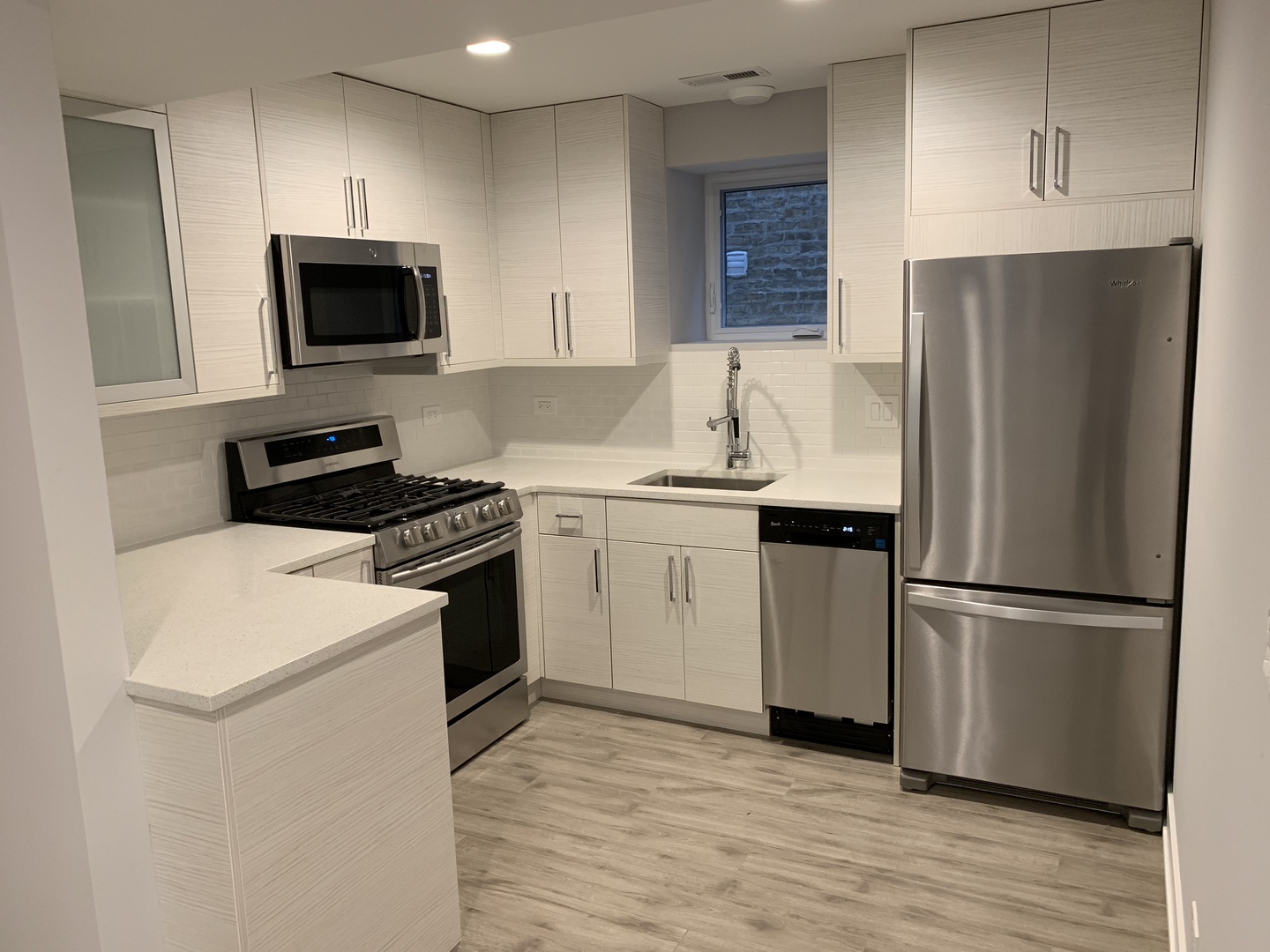 3706 North Drake Avenue, Unit G Chicago, IL 60618 - Photo 5 of 23 a kitchen with a sink a microwave a refrigerator and cabinets