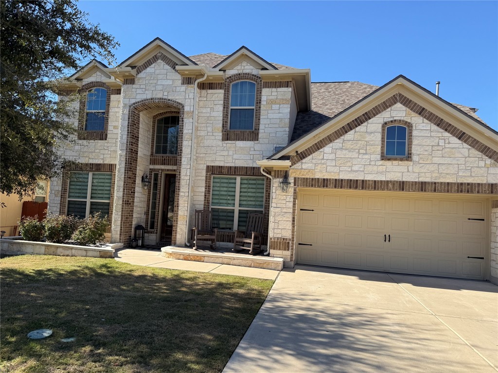 Undisclosed Address Leander, TX 78641 - Photo 1 of 8 French country home with stone siding, concrete driveway, a garage, and a front yard