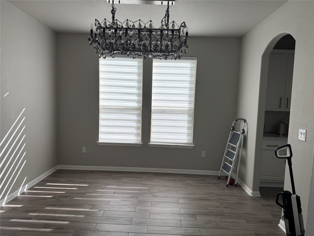 Undisclosed Address Leander, TX 78641 - Photo 4 of 8 Dining area with arched walkways, wood tiled floors, and a textured ceiling