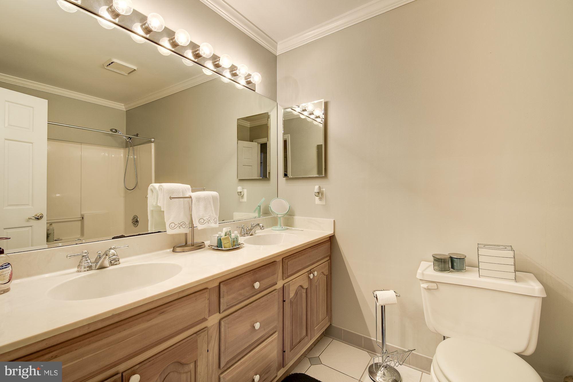 10920 Ward Road Dunkirk, MD 20754 - Photo 36 of 63 a bathroom with a toilet a double vanity sink and a mirror