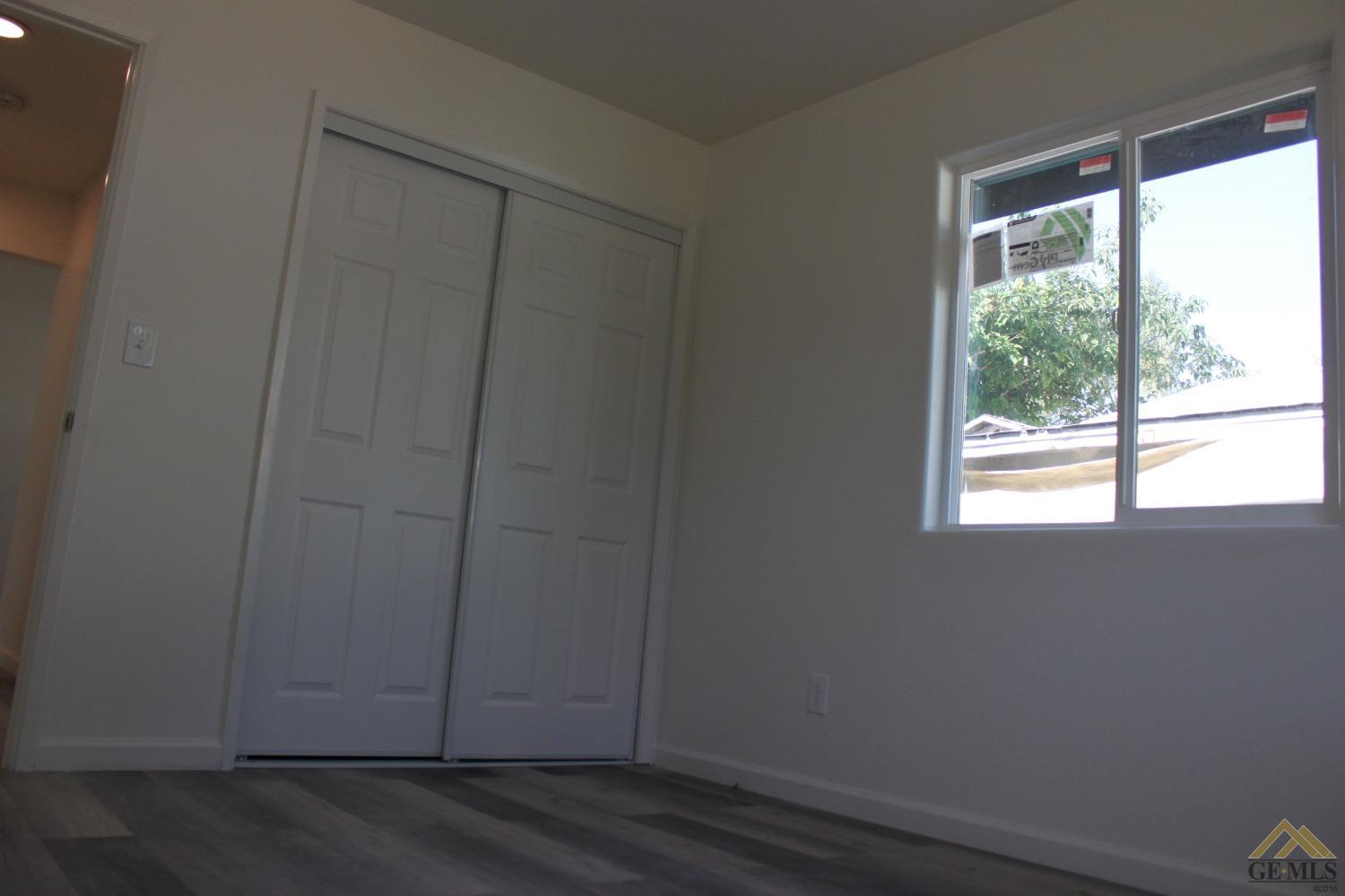 Undisclosed Address Wasco, CA 93280 - Photo 19 of 26 a view of an empty room with wooden floor and fan