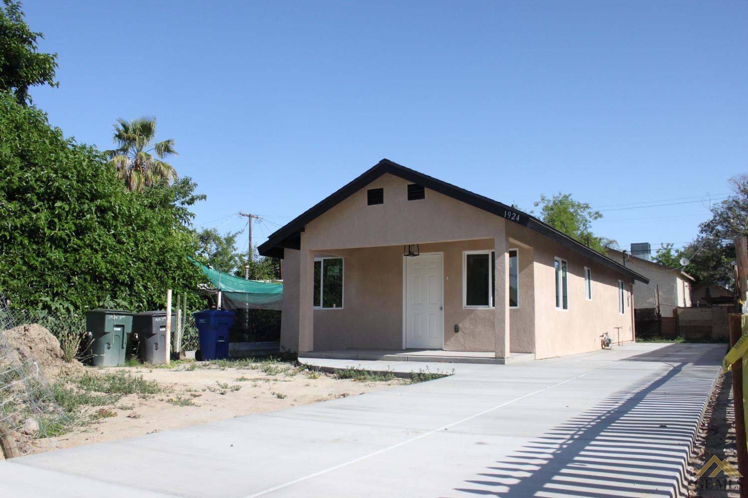 Undisclosed Address Wasco, CA 93280 - Photo 2 of 26 a front view of a house with a yard and garage