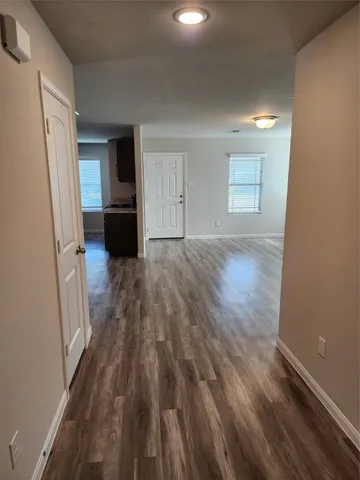 wooden floor in an empty room with a kitchen