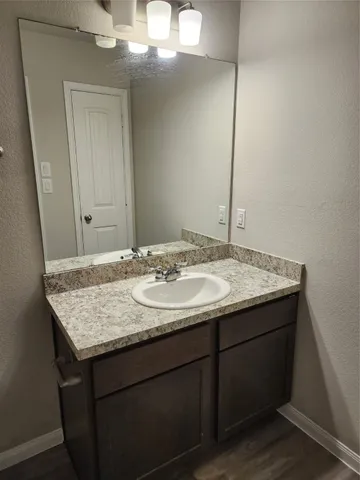 a bathroom with a granite countertop sink and a mirror