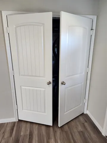 an empty room with wooden floor and closet area