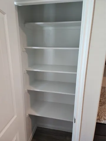 a view of walk in closet with empty racks
