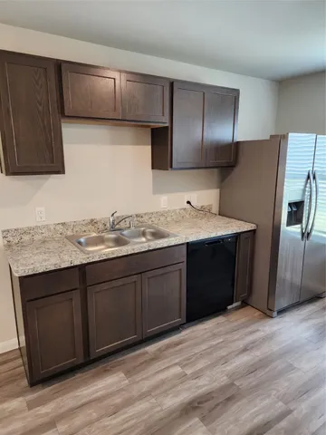 a kitchen with stainless steel appliances granite countertop a refrigerator and a sink