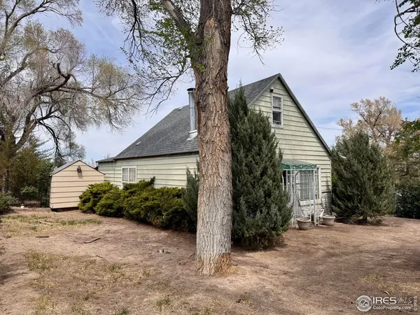 a view of a house with a tree in front of it