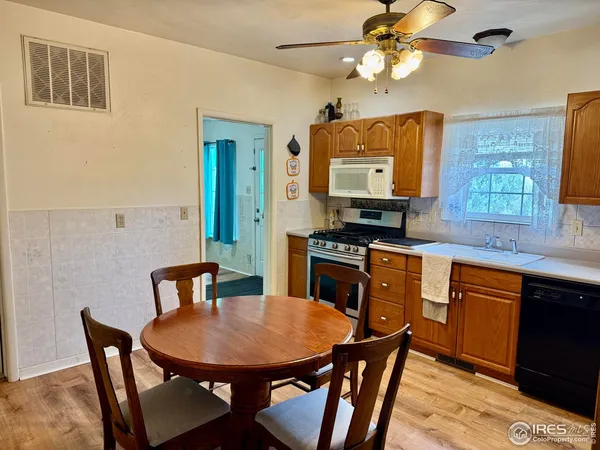 a kitchen with stainless steel appliances granite countertop a sink a stove a dining table and chairs