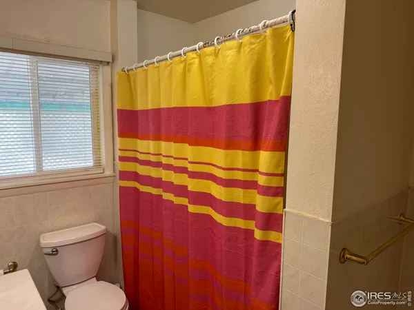 a bathroom with a toilet and shower curtain