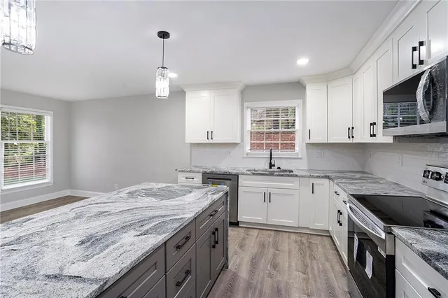 a kitchen with stainless steel appliances granite countertop a sink stove and refrigerator