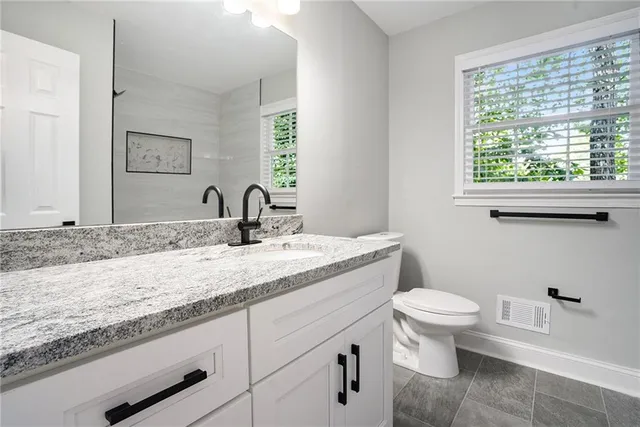 a bathroom with a granite countertop sink and a mirror
