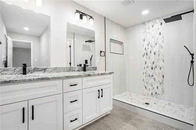 a bathroom with a double vanity sink mirror and shower