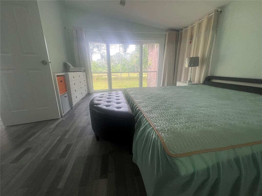 5855 Jack Brack Road St. Cloud, FL 34771 - Photo 18 of 86 a bedroom with a bed and wooden floor
