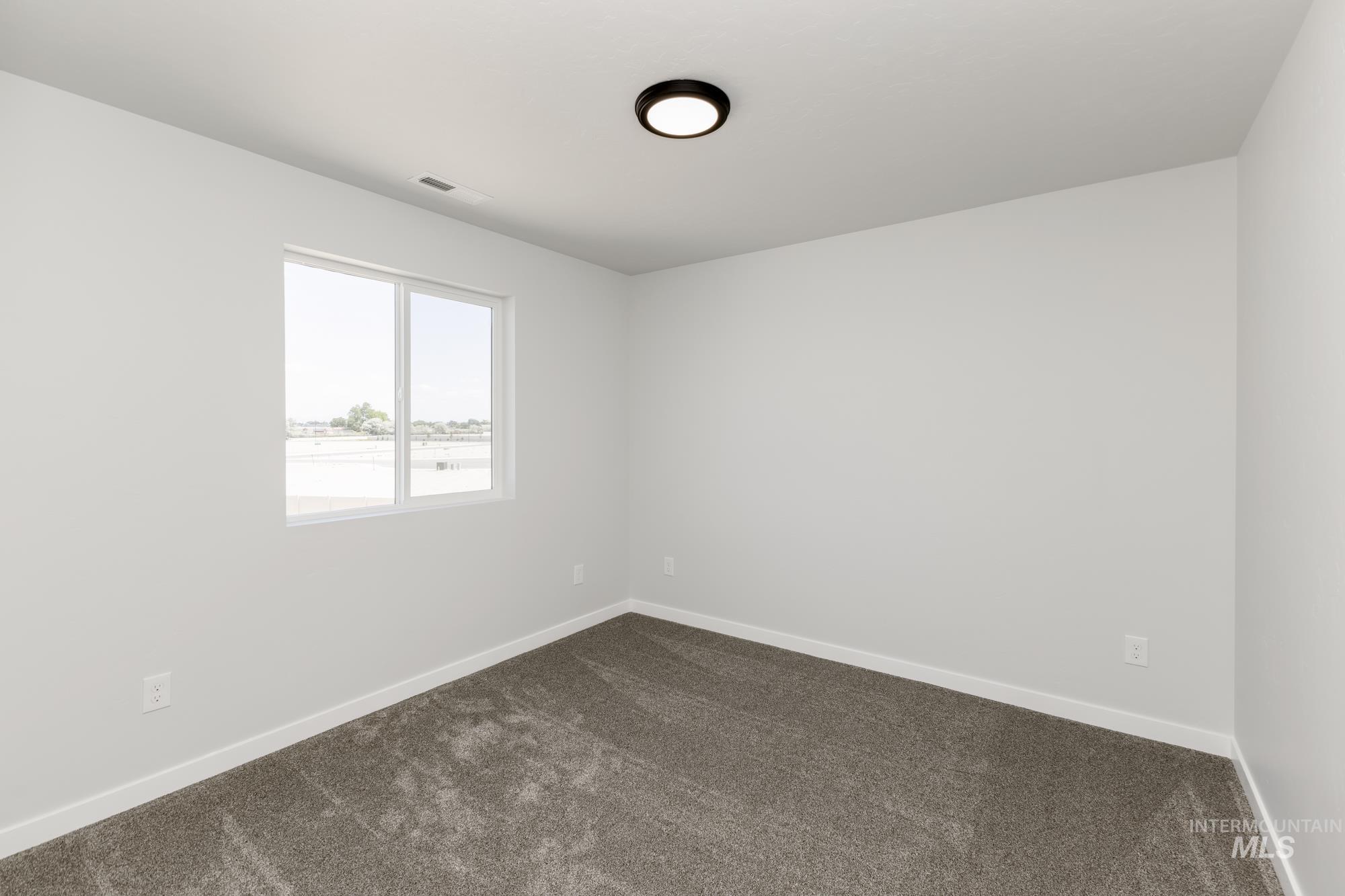 3218 North Waterbrook Way Star, ID 83669 - Photo 18 of 27 Empty room with dark carpet and baseboards