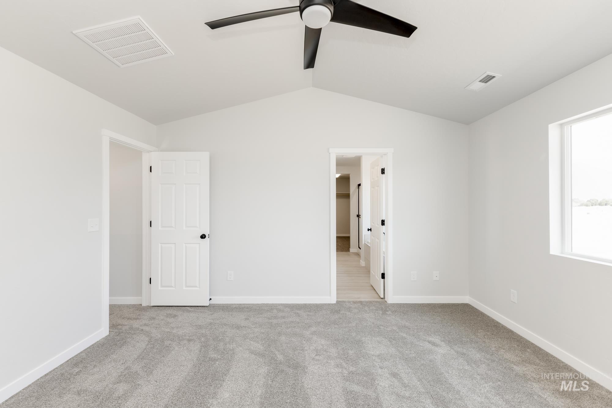 3218 North Waterbrook Way Star, ID 83669 - Photo 23 of 27 Unfurnished bedroom with vaulted ceiling, light carpet, ensuite bathroom, and ceiling fan
