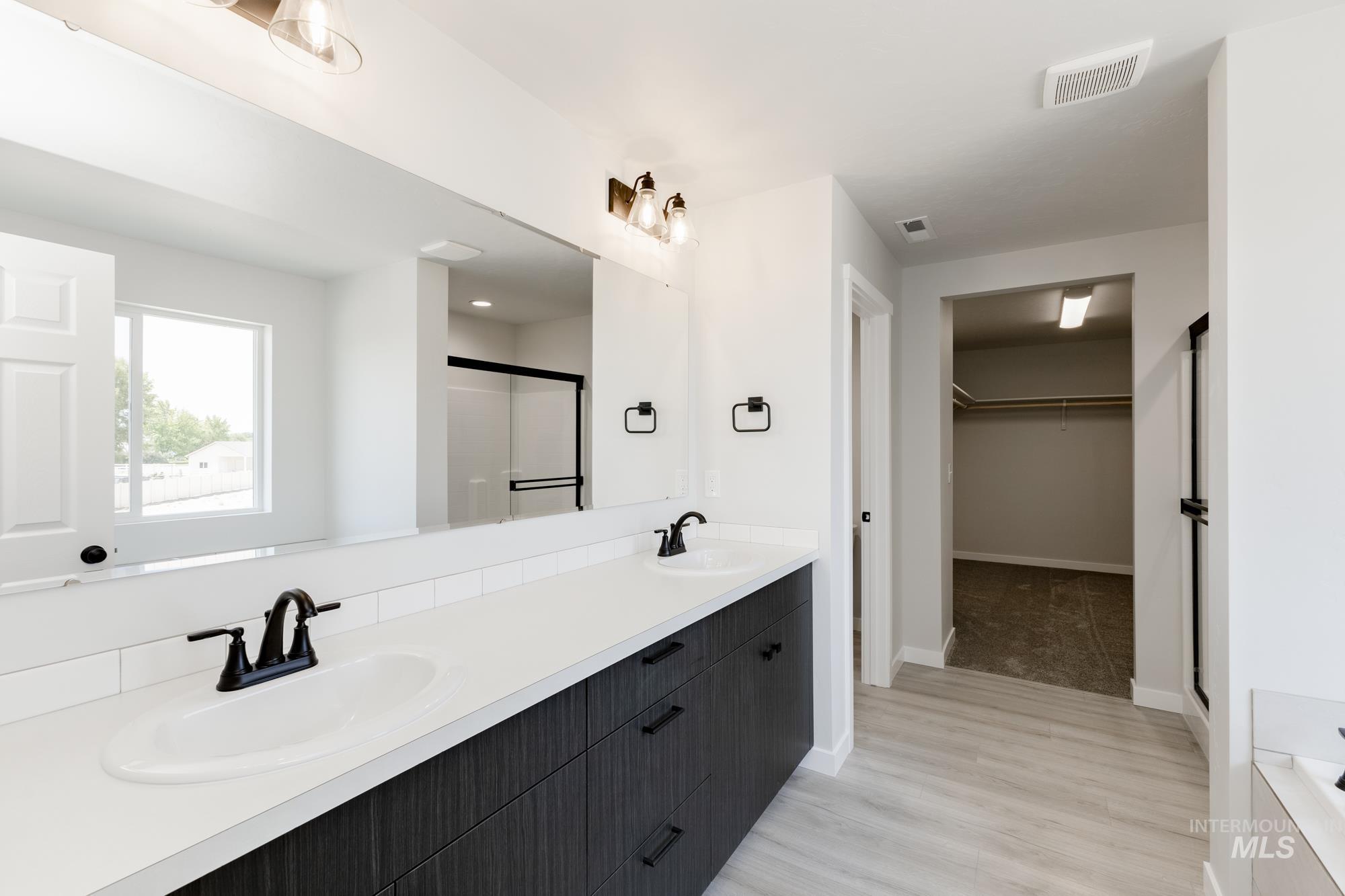 3218 North Waterbrook Way Star, ID 83669 - Photo 24 of 27 Full bath featuring double vanity, a shower stall, a spacious closet, and light wood-type flooring