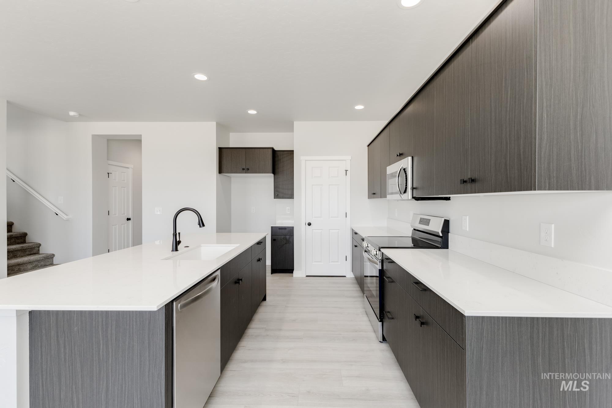 3218 North Waterbrook Way Star, ID 83669 - Photo 5 of 27 Kitchen featuring stainless steel appliances, modern cabinets, recessed lighting, light stone countertops, and a center island with sink