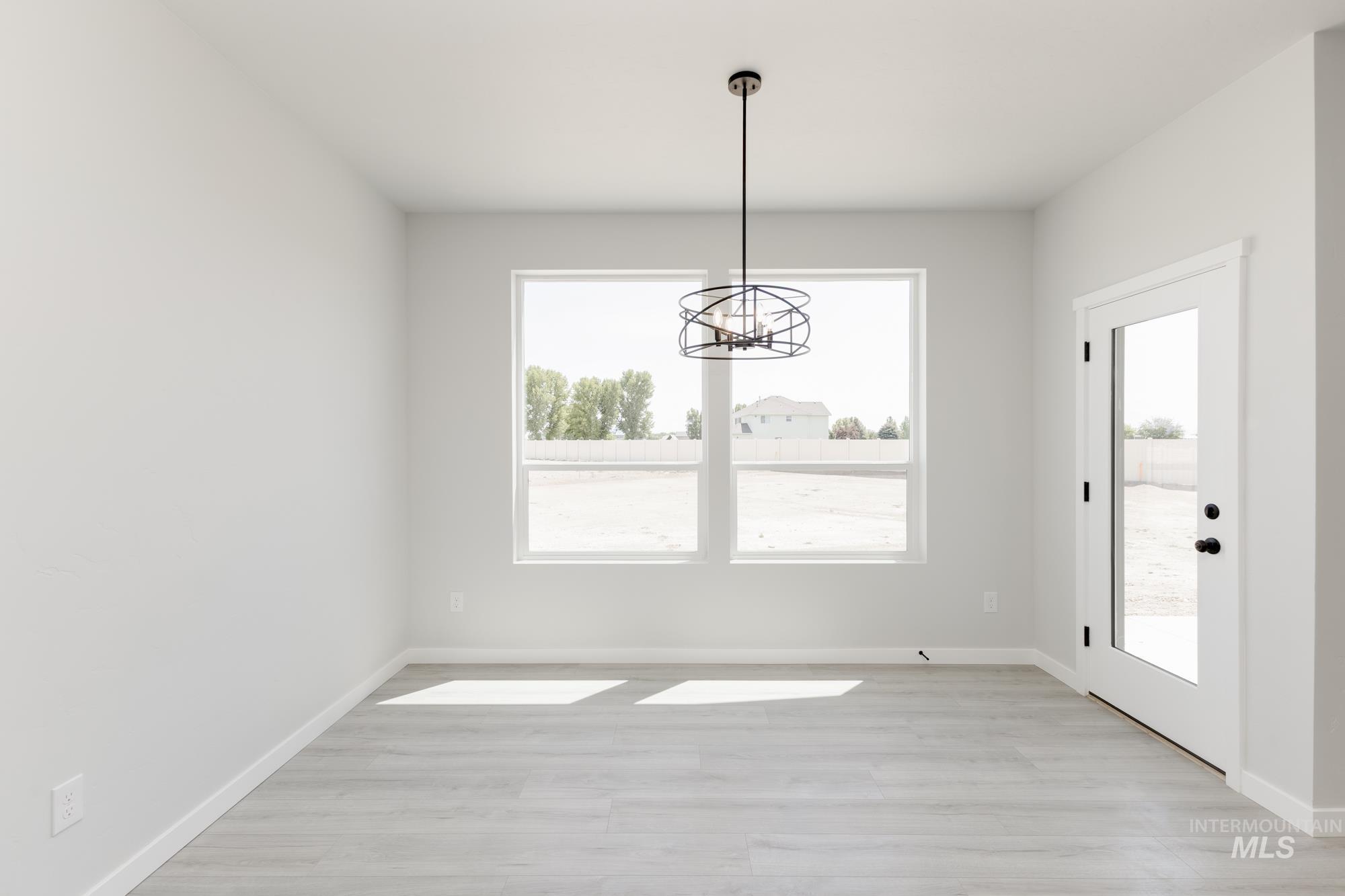 3218 North Waterbrook Way Star, ID 83669 - Photo 6 of 27 Unfurnished dining area with light wood finished floors and a chandelier