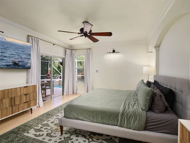 a bed sitting in a bedroom next to a cabinet with a flat tv screen and wooden floor