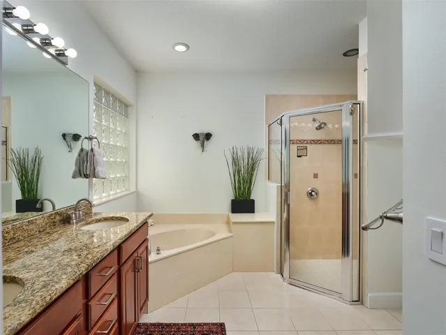 a bathroom with a granite countertop sink a mirror and a bathtub