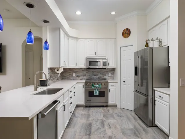 a kitchen with granite countertop a refrigerator and a sink