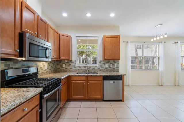 a kitchen with stainless steel appliances granite countertop a stove a sink and a microwave