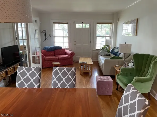 a living room with furniture a flat screen tv and windows