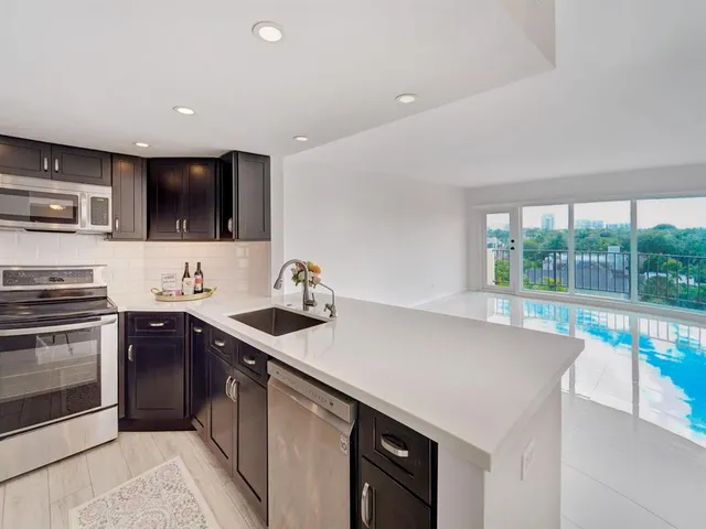 a kitchen with stainless steel appliances a sink stove and cabinets