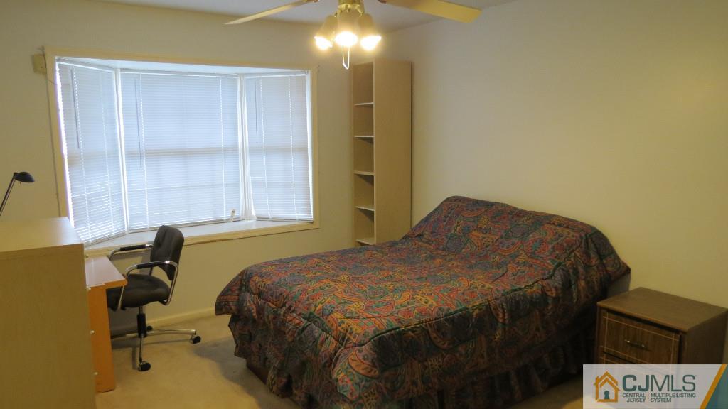 216 Edpas Road New Brunswick, NJ 08901 - Photo 5 of 18 a bedroom with a bed and a table in it