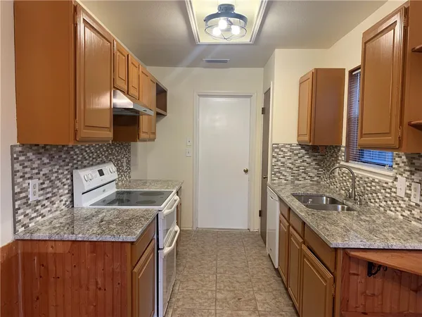 a kitchen with a sink stove and cabinets