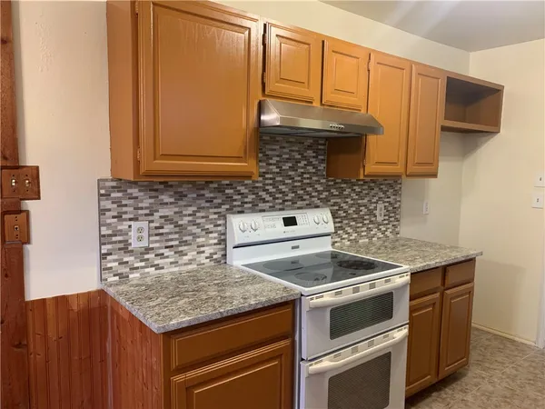 a kitchen with granite countertop cabinets stove and microwave
