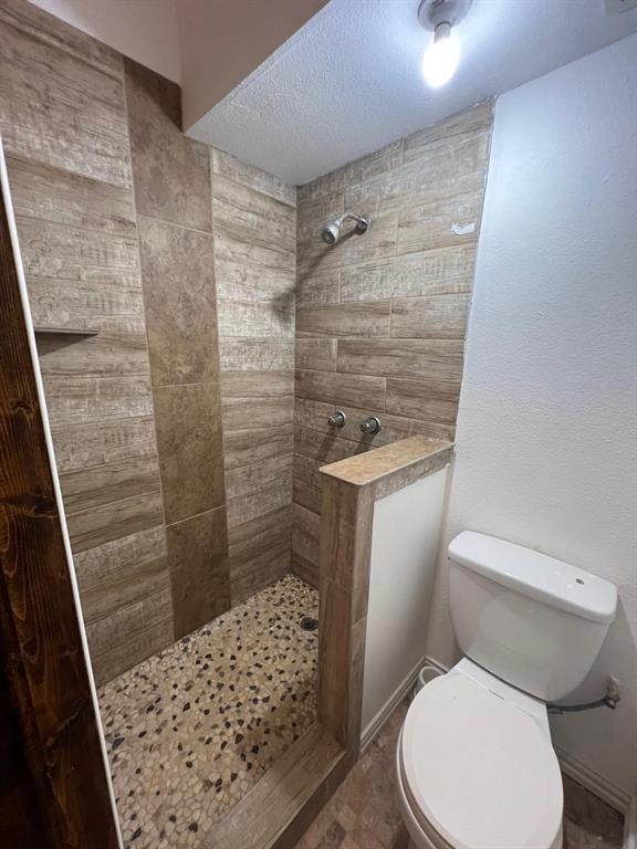 6707 Elam Road Dallas, TX 75217 - Photo 12 of 18 a white toilet sitting next to a shower curtain