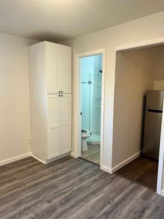 6707 Elam Road Dallas, TX 75217 - Photo 13 of 18 a view of an empty room with wooden floor and a bathroom