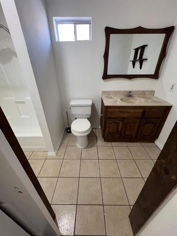 6707 Elam Road Dallas, TX 75217 - Photo 7 of 18 a bathroom with a toilet a sink and mirror