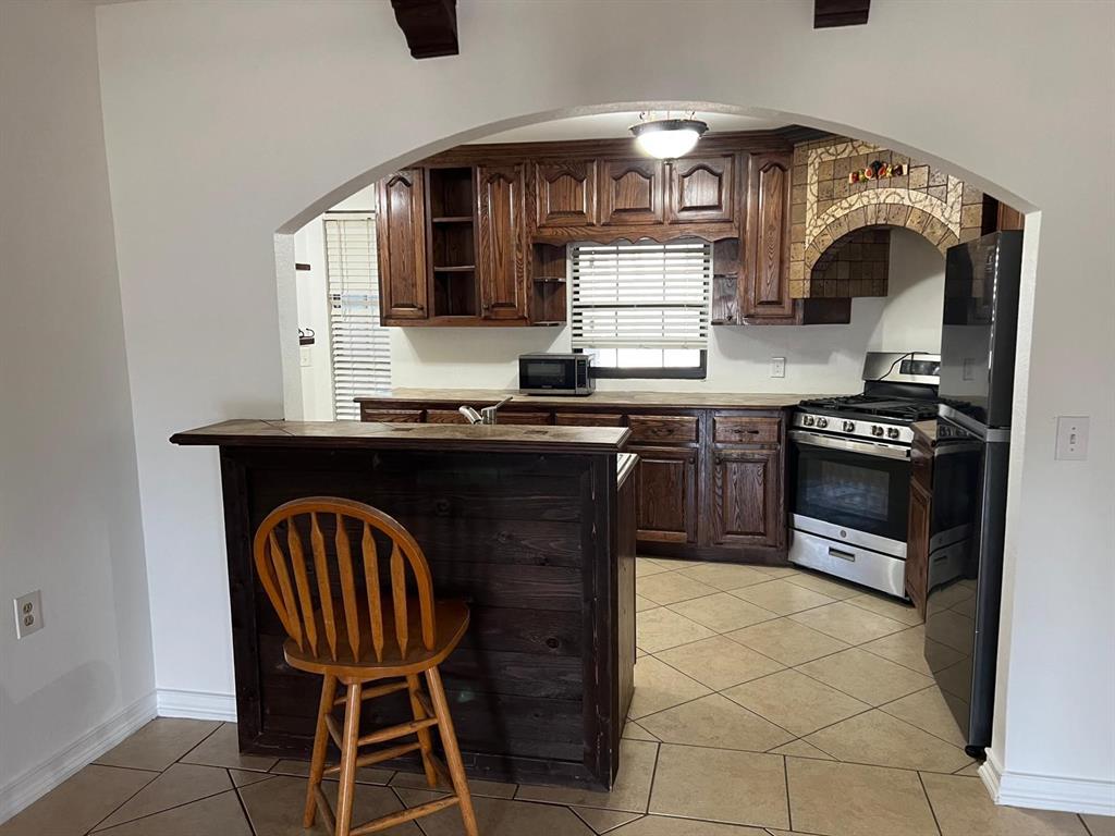 6707 Elam Road Dallas, TX 75217 - Photo 8 of 18 a kitchen with a stove a sink and a microwave