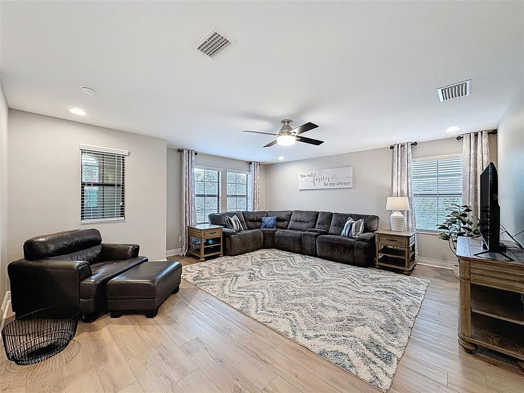 4312 Burdick Loop Odessa, FL 33556 - Photo 24 of 55 a large bedroom with a bed a couch and a flat screen tv