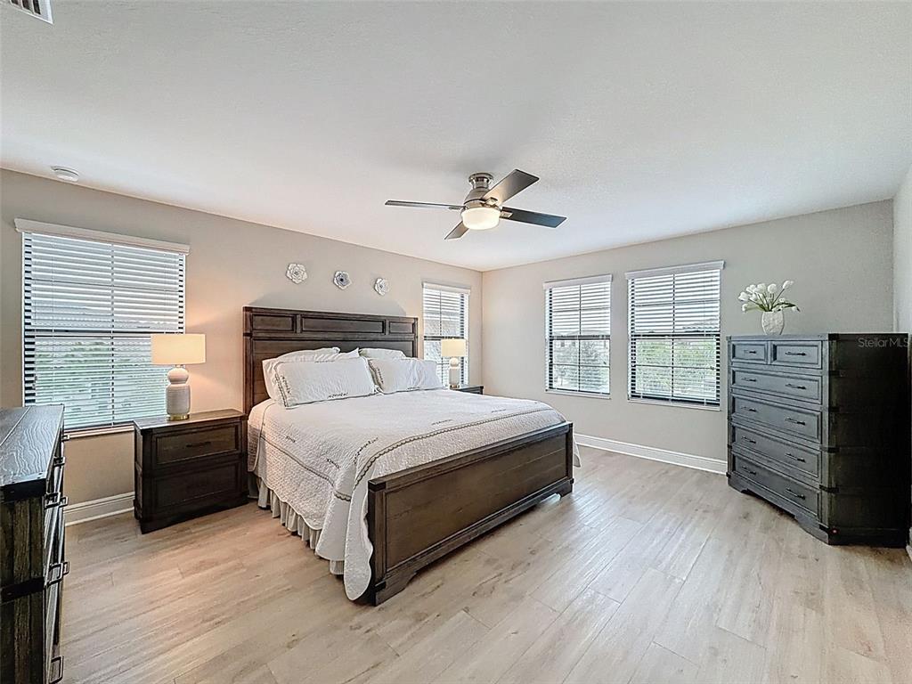 4312 Burdick Loop Odessa, FL 33556 - Photo 25 of 55 a bedroom with a large bed and a flat tv screen on dresser