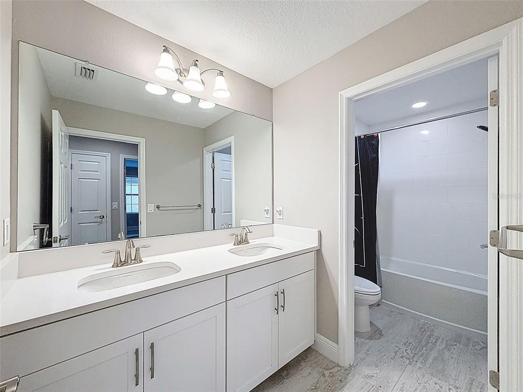 4312 Burdick Loop Odessa, FL 33556 - Photo 33 of 55 a bathroom with a double vanity sink a toilet and a mirror