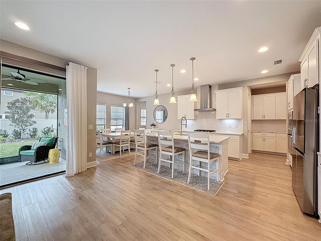 4312 Burdick Loop Odessa, FL 33556 - Photo 9 of 55 a dining room with stainless steel appliances a large counter top a stove a sink and a refrigerator