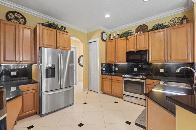 a kitchen with stainless steel appliances granite countertop a refrigerator sink and stove